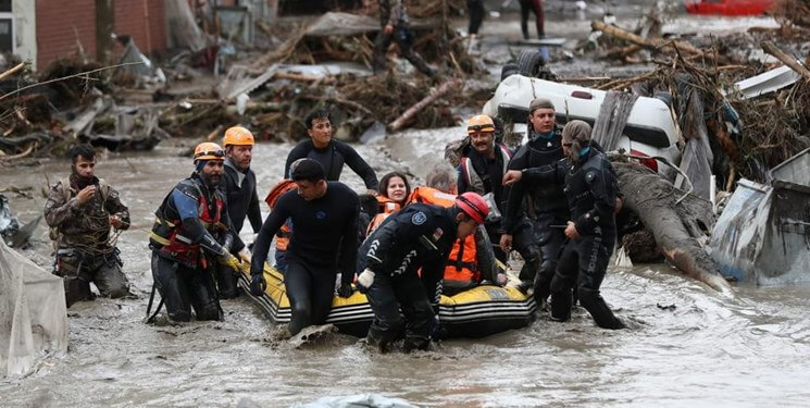 people on a flooded street that carry an inflatable