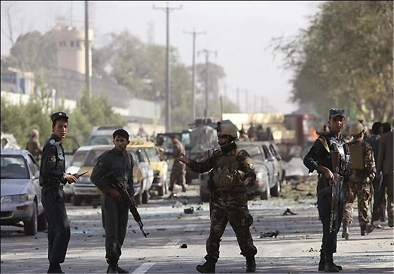 four men with weapons are standing on a chaotic street 