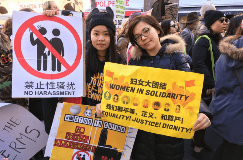 two women holding feminist posters