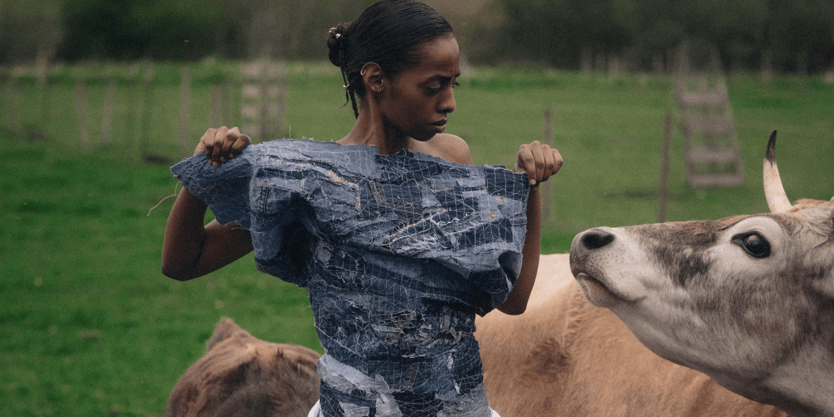 a woman wearing denim looking at a cow in REVOLVE: A Story About Denim Couture and Environmental Awareness