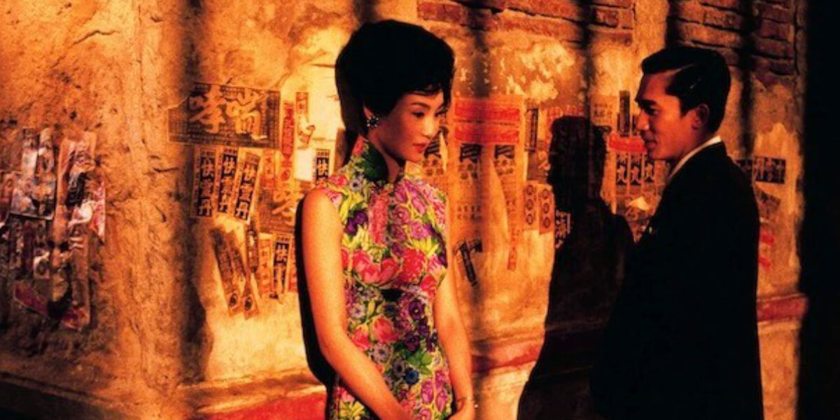 A famous frame from the movie "In the Mood for Love (2000), with Maggie Cheung and Tony Leung bathed in warm golden light, capturing the film’s timeless romance and visual elegance.