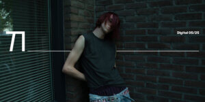 Kilian Smits leans against a brick wall in low-slung jeans and a sleeveless shirt, captured in raw natural light by photographer Isha van Dijk.