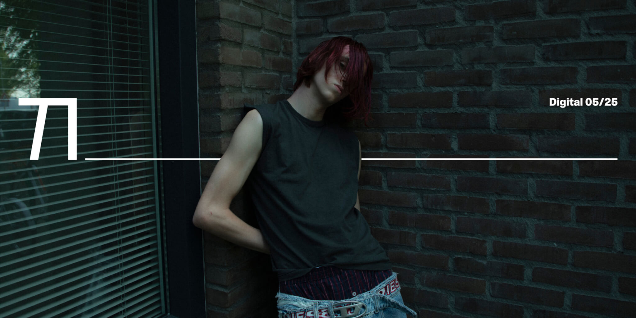 Kilian Smits leans against a brick wall in low-slung jeans and a sleeveless shirt, captured in raw natural light by photographer Isha van Dijk.