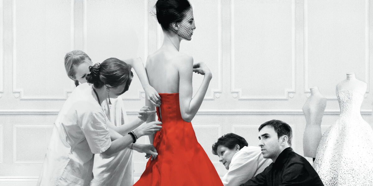 Fashion designer Raf Simons with team fitting a red couture gown on a model at Dior atelier, from the documentary Dior and I