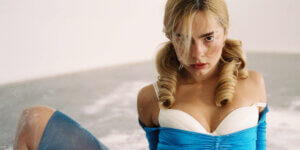 Addison Rae posing in blue satin dress with vintage curls, embodying her new pop star persona