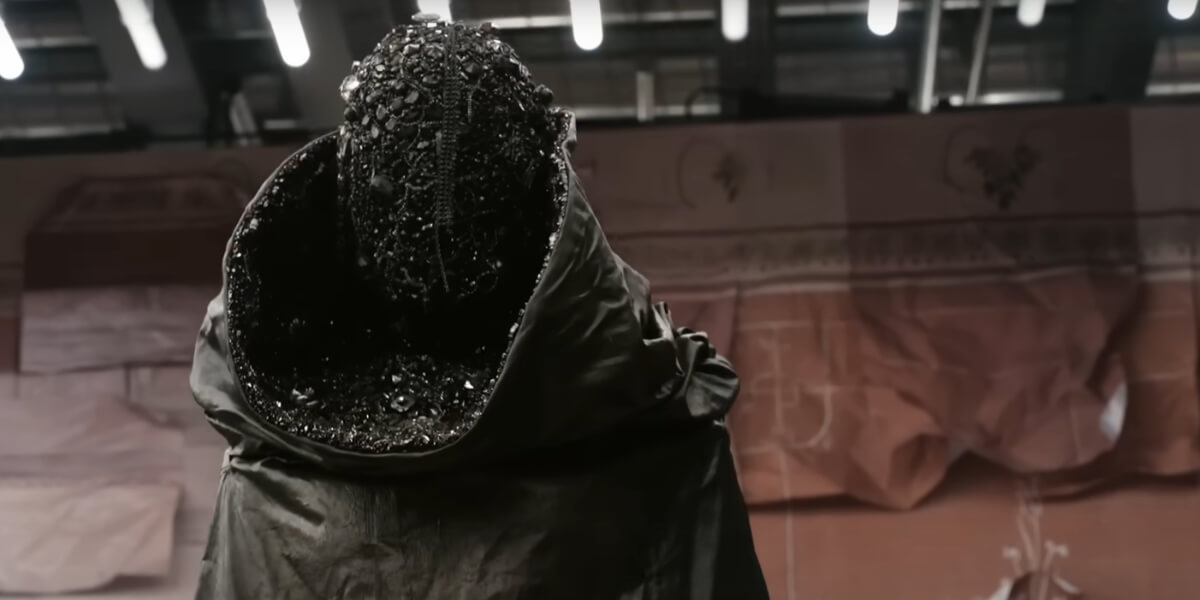Close-up of a textured black mask from Maison Margiela Artisanal 2025 collection, designed by Glenn Martens, inspired by Gothic architecture and surrealism.