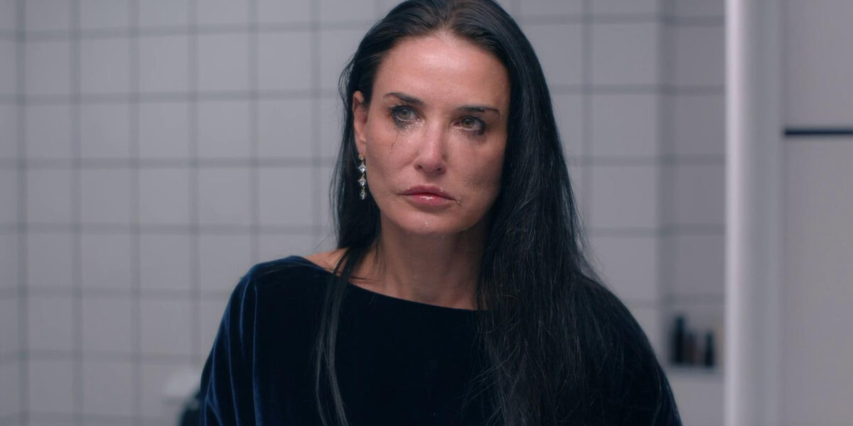 Demi Moore in The Substance, crying in a bathroom, symbolizing beauty, aging, and the rise of facelifts in Guadalajara.
