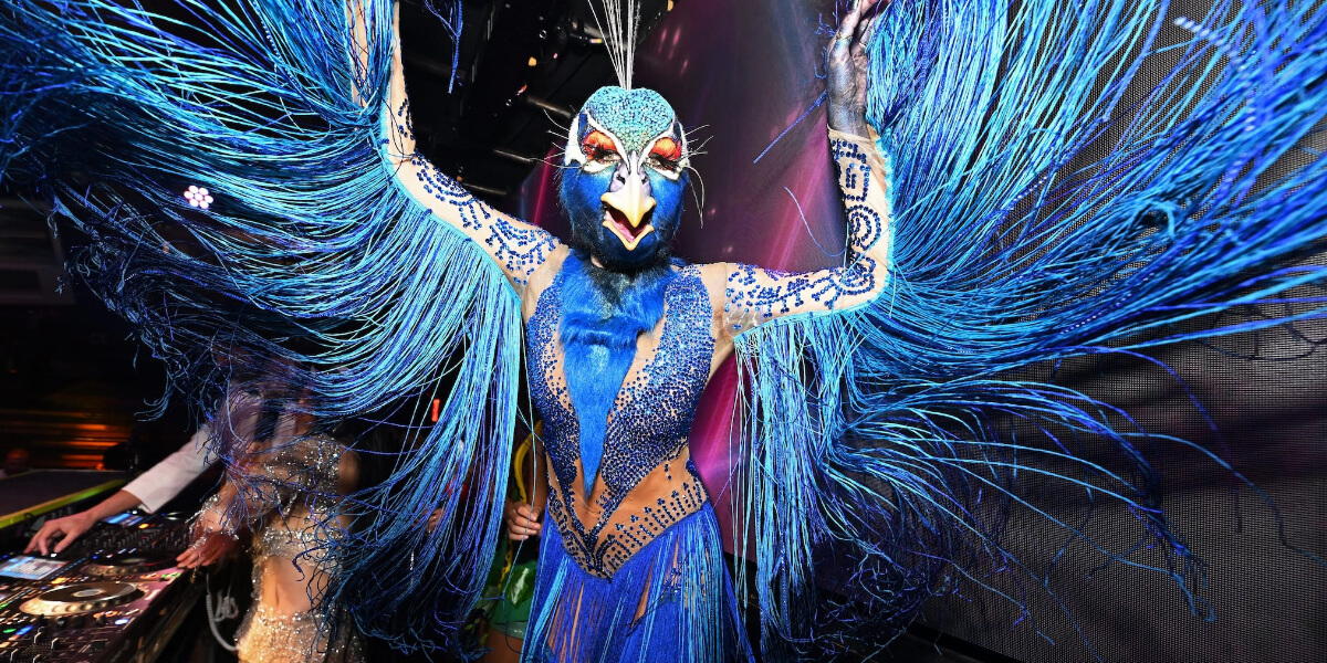 Heidi Klum wearing her 2024 Halloween Peacock costume at her annual Halloween party, featuring vibrant blue feathers and Cirque du Soleil-inspired wings.