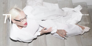 Gina-Lisa Lohfink photographed by Chris Haimerl for TITLE’s November Digital Cover, lying on concrete stairs in an all-white look with sculptural styling.