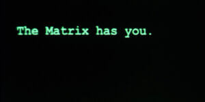 Green computer-style text reading “The Matrix has you” on a black screen, referencing digital control and AI themes.