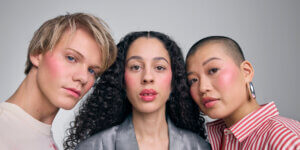 A diverse trio of models wearing natural, retouch-free makeup with soft blush tones from the IsaDora makeup campaign, showcasing real skin and inclusive beauty.