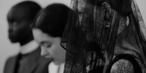 Black-and-white image of female fashion models wearing lace veils and dark gothic-inspired garments, evoking Gothic Revival aesthetics in contemporary fashion.