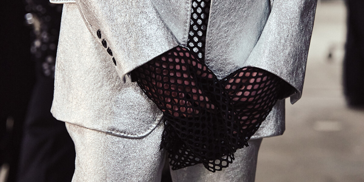 Close-up of John Lawrence Sullivan AW26 menswear look featuring silver tailored suit and black mesh gloves inspired by boxing at Berlin Fashion Week