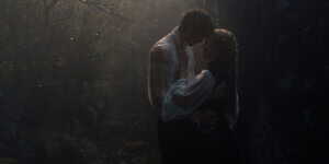 Romantic couple resembling Heathcliff and Catherine in the new Wuthering Heights movie starring Jacob Elordi and Margot Robbie, embracing in a dark forest on Valentine’s Day