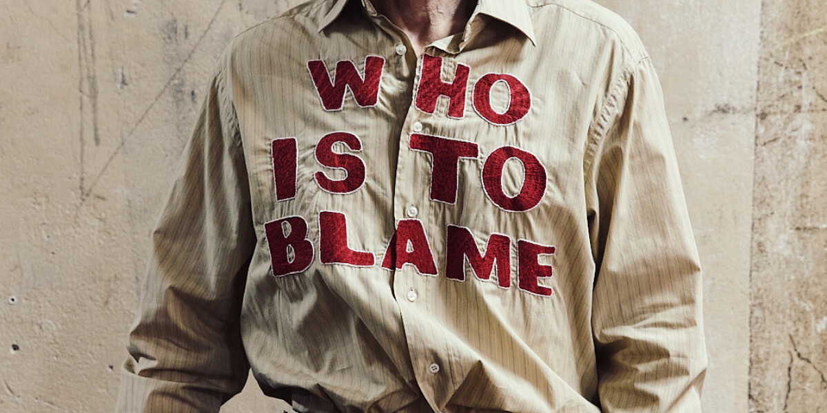 Model walking the runway in a BUZIGAHILL AW26 upcycled suit during Berlin Fashion Week, showcasing the RETURN TO SENDER collection focused on sustainable fashion.