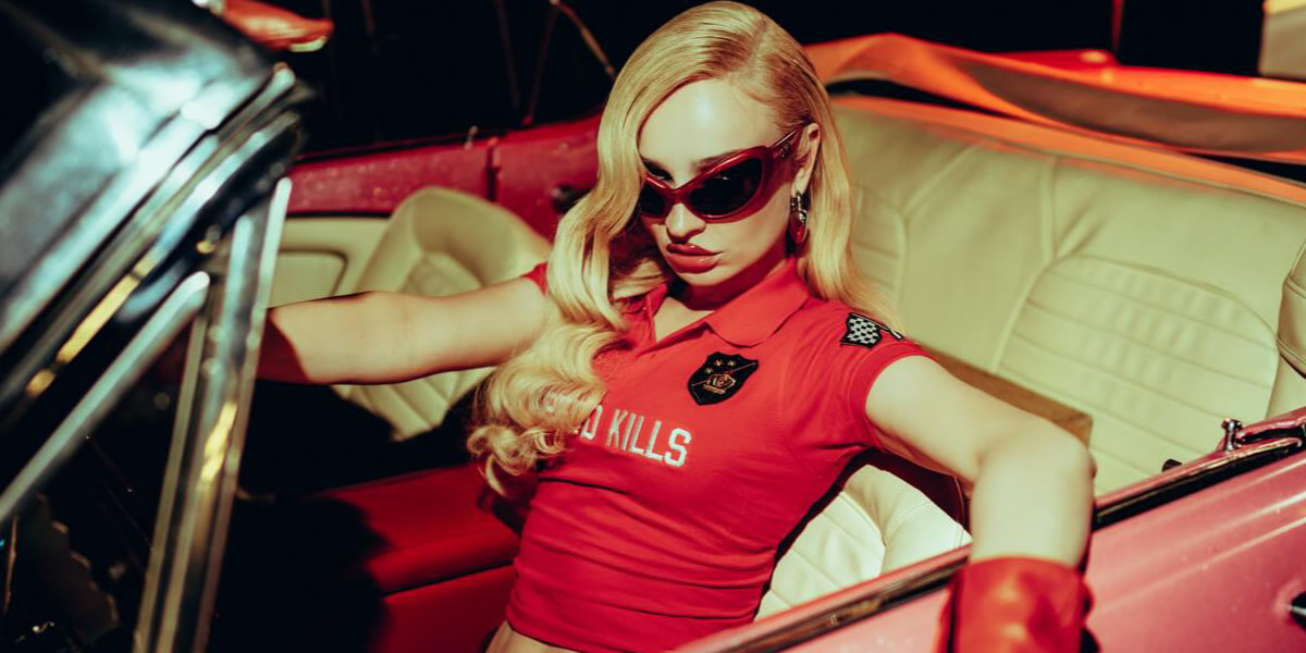 Editorial-style image associated with Kim Petras featuring a woman in red sunglasses sitting in a vintage convertible, reflecting queer nightlife, female empowerment, and hyper-feminine club culture.