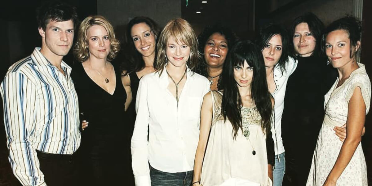 Cast of The L Word posing together, representing queer romance, lesbian relationships, female friendship, and the female gaze in television.