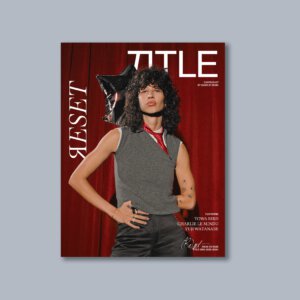 Cover of ЯESET Magazine Issue 09 featuring musician and songwriter Towa Bird, photographed by Charlie Denis. Towa Bird wears a grey sleeveless knit top with black trousers against a deep red backdrop, introducing the theme of reset, self-discovery, and contemporary culture.