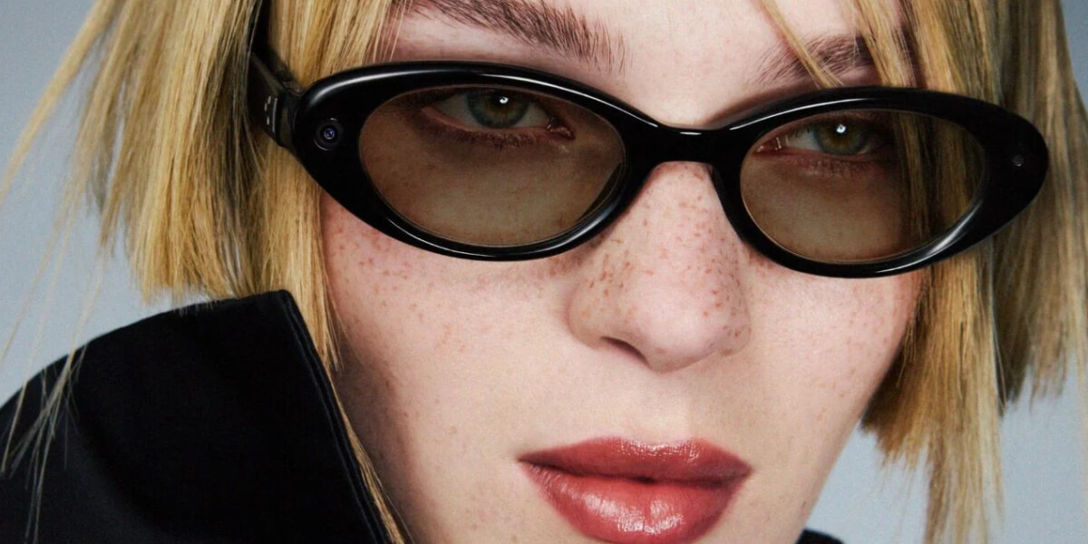 Close-up portrait of a blonde model wearing oversized black statement sunglasses, highlighting the big sunglasses trend in 2026 fashion.