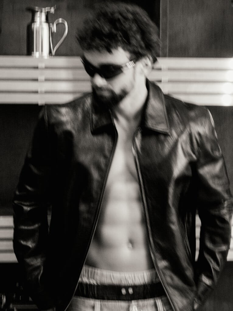 Arda Saatçi shows his six-pack abs while posing shirtless in a leather jacket, sunglasses, boxers and jeans for TITLE Magazine’s Berlin Psycho fashion editorial