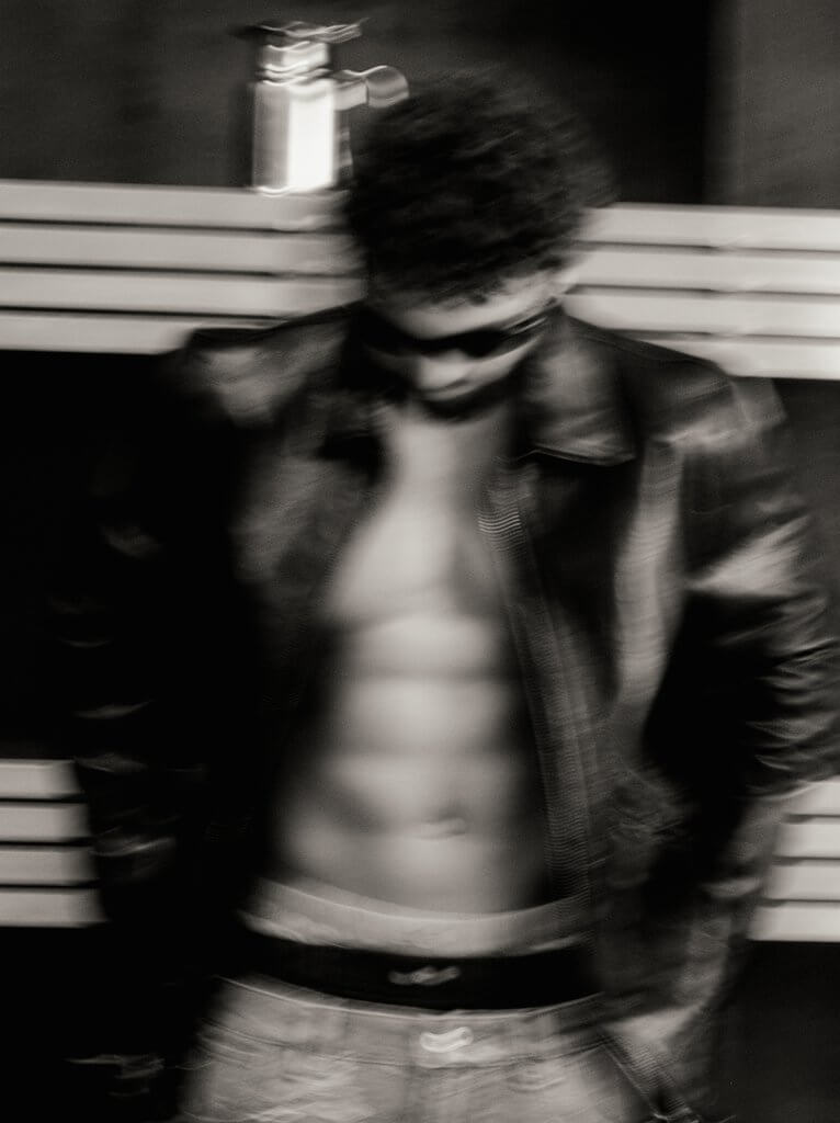 Arda Saatçi shows his six-pack abs while posing shirtless in a leather jacket, sunglasses, boxers and jeans for TITLE Magazine’s Berlin Psycho fashion editorial