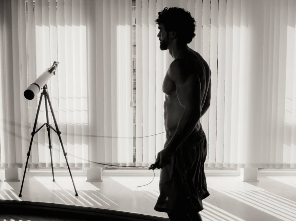 Arda Saatçi jump ropes shirtless in shorts in a black-and-white image for TITLE Magazine’s Berlin Psycho fashion editorial